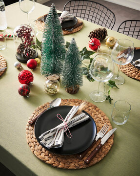 Christmas and new year dinner table serving, green tablecloth, accessory, tree.