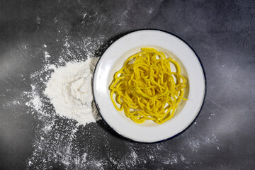 Top view of yellow noodles in a white plate