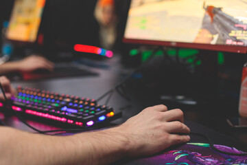 Cyber sport e-sports tournament, team of professional gamers, gamer's hands on mouse and keyboard, pushing button, gamers playing in competitive moba, strategy fps game in a cyber games arena club