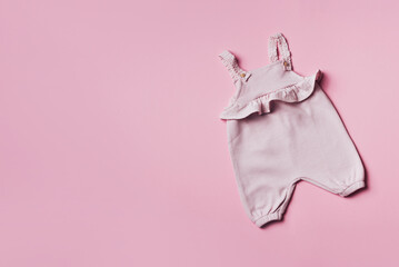 Pink baby girl romper on pastel backgroundd. Set of baby clothes and accessories for spring or summer. Fashion childs outfit. Flat lay, top view. Copy space
