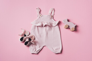 Set of baby girl clothes, shoes, accessories on pink backgroundd. Fashion newborn clothes. Flat lay, top view. Copy space