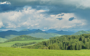 Obraz premium View of a summer day in the mountains, green meadows, mountain slopes and hills, countryside