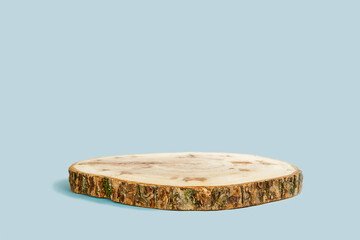 Wooden Podium with Bark. Real Wood Slab. Empty Round Natural Form. Pedestal for Showing Product, Eco Organic Cosmetic, Jewelry. Trendy Minimal Style Mock Up Presentation. Blue Studio Background. 3d