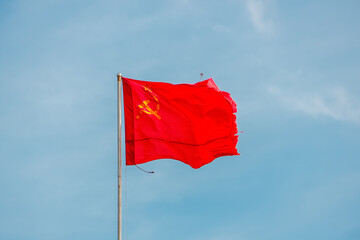 The Red Banner of Victory in World War II is developing in the wind against a clear sky