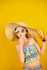 Child teenager girl in swimsuit, straw hat and sunglasses with lemonade