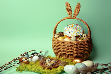 Easter decorations in a basket with rabbit ears. Easter cake and eggs on moss, quail eggs and...