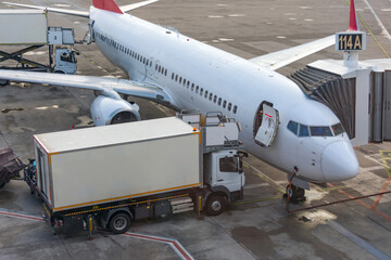 Trucks with a lift providing in-flight catering for a passenger airliner jet.