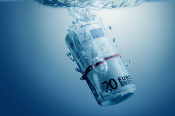 European financial  problems concept. Close up Euro banknote sinking in water as symbol of ...