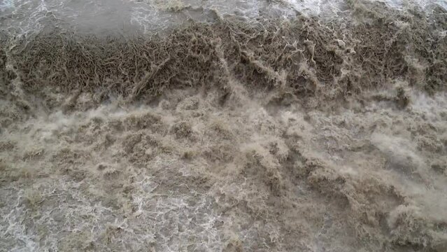 4K. Alternative energy, hydroelectric power station on the river, a view from a height of the dam system, energy production. A waterfall from a powerful current breaks through the locks of the dam.
