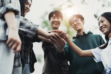 Fototapeta premium Group of happy Asian college students putting their hands together. success team building concept
