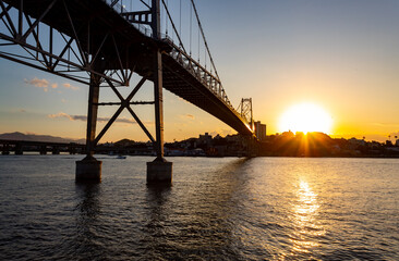 Fototapeta na wymiar no horizonte o pôr-do-sol e a silhueta da ponte Hercílio luz de Florianopolis Santa Catarina Brasil Florianópolis