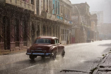 Vintage car driving through the rain in Havana. © Dan