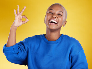 Portrait, laughing and black woman with ok sign in studio isolated on a yellow background. Success,...