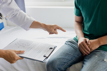 Male health concepts. The young man with pain consulted a doctor for treatment. The doctor is interviewing and advising the patients. - obrazy, fototapety, plakaty