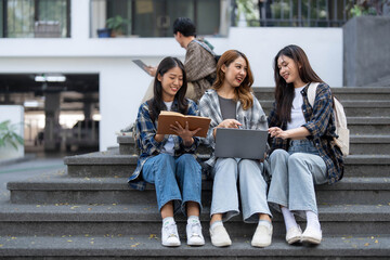Group of Asian college student reading books and tutoring special class for exam on grass field at outdoors. Happiness and Education learning concept. Back to school concept. Teen and people theme.