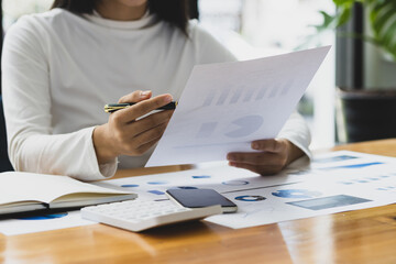 Accountant working on consolidated financial report of corporate operations, consultant auditing finance data (balance sheet, income statement) on laptop with business charts, fintech.