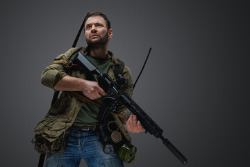 Portrait of man survivor in post apocalyptic style with gun and bow.