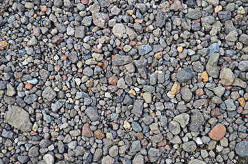 pile of mixed colored fine and coarse pebbles. rock background. stone wall texture