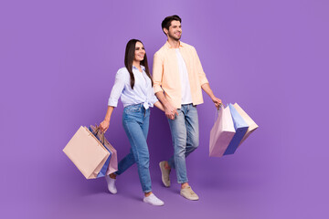 Full size profile photo of two attractive lovely people hold arms bags walk empty space isolated on...