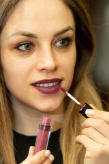 Woman applying lipstick on the lips with makeup brush. Make-up And Cosmetics Concept.