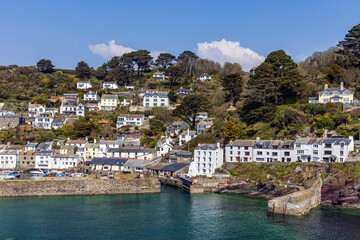 Fototapeta na wymiar The fishing village of Polperro, with its harbour wall and narrow entrance to the inner harbour. Polperro is a charming and picturesque fishing village in south east Cornwall. 