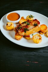 Vertical shot of grilled pork and corn with red sauce