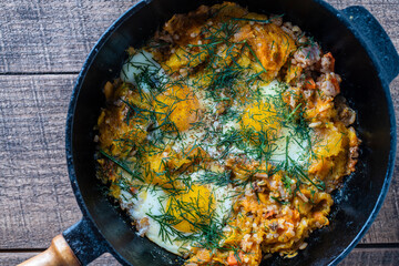 Boiled rice with fried eggs, pumpkin, peppers, carrots and onions in a cast iron pan, closeup. Food background. Healthy food