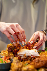hungry woman hand holding and eatting fried chicken meat in pub