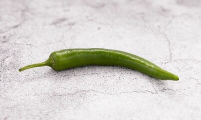 Closeup of a fresh jalapeno pepper on a white table