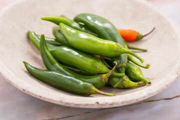 Closeup of fresh jalapeno peppers on a white table
