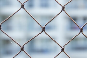 Closeup shot of a chain link fence with a blurry white background
