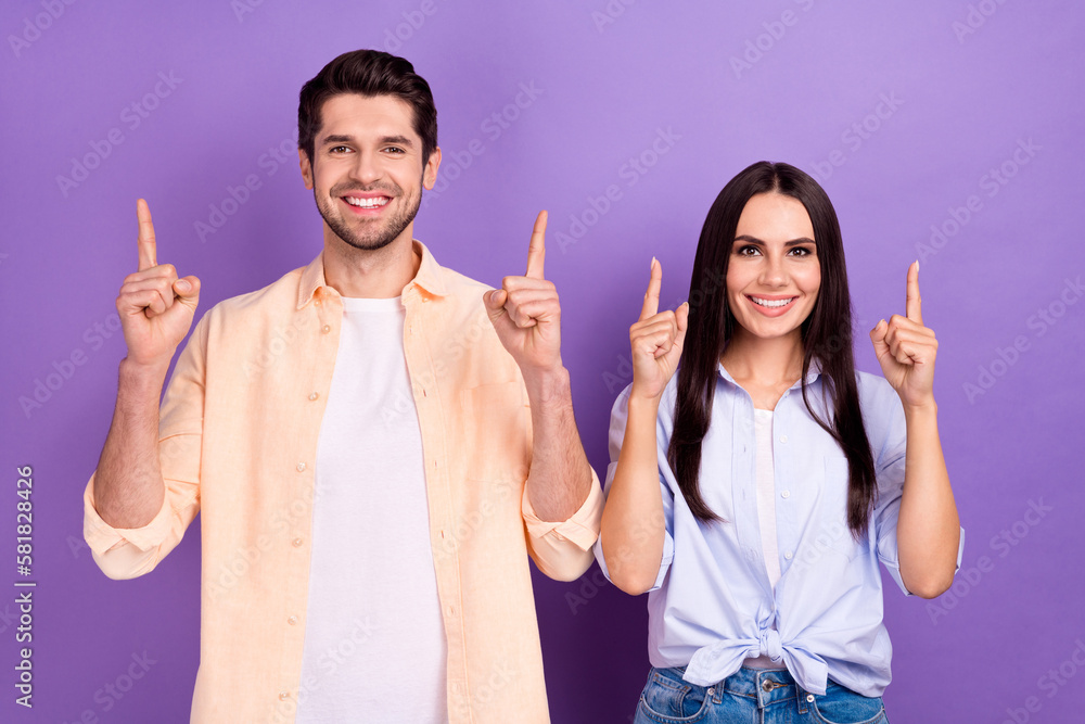 Poster portrait of two nice positive people toothy smile indicate fingers up empty space isolated on purple