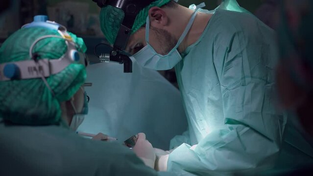Concentrated surgeon and nurse checking stiches during operation in slow motion. Intelligent focused Middle Eastern man and Caucasian woman performing surgery in operating room