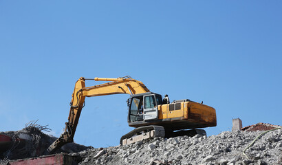 Hydraulic breaker hammer excavator at demolition work. Excavator, digger taking down building. Demolition of an old building. Complete demolition work of the building with hydraulic shears. 