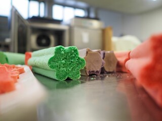 pastry chef slicing red violet yellow and green star and heart shaped coloured buns