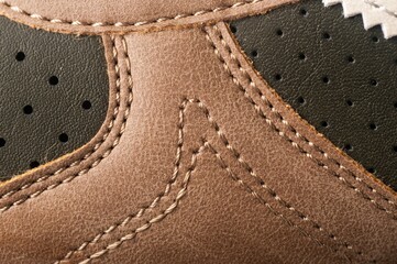 Closeup of a Brown canvas sneaker against a black background