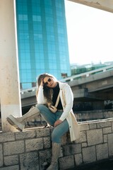 Vertical of a fashionable Argentinian woman with sunglasses touching her head