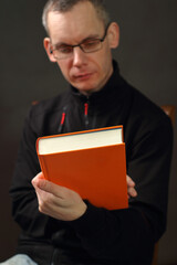 young man is watching an orange book