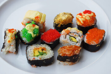 Colorful homemade sushi rolls on white plate. Variety topping. Concept, Traditional Japanese food. Cuisine, culture eating lifestyle. Favorite street food in Thailand.            