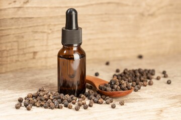 Peppercorn essential oil still life. Amber glass bottle with pipette