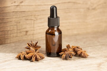 Star anise essential oil still life. Amber glass bottle with pipette