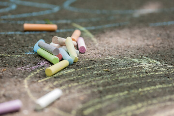 colorful crayons on asphalt in summer, close-up, space for text. Children Protection Day
