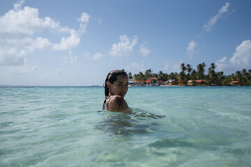 Beautiful tan Colombian women in crystal water on Caribbean island in San Blas