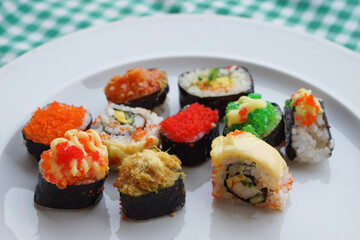 Colorful homemade sushi rolls on white plate. Variety topping. Concept, Traditional Japanese food. Cuisine, culture eating lifestyle. Favorite street food in Thailand.                               