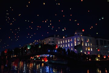Fototapeta na wymiar Beautiful view of sky lanterns floating in the night in Volos, Greece, creating the Christmas spirit