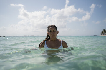 Beautiful tan Colombian women in crystal water on Caribbean island in San Blas