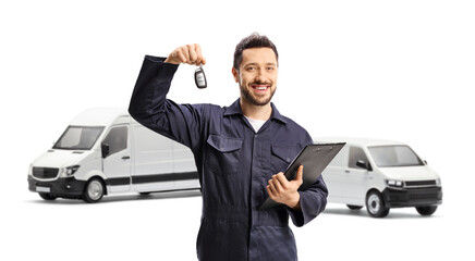 Auto mechanic holding a vehicle key in front of two white vans