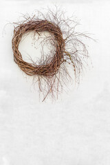 Fototapeta premium On the wall is a decorative wicker wicker wreath. Gray wall in the background. Traditional seasonal decoration. Traditional seasonal decoration. Copy space. Background for brochure.