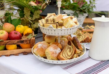 Selective focus of a two-tiered dessert stand with baked goods and fruits on a party table