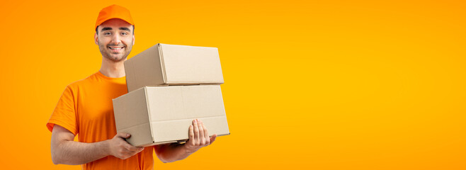 Delivery man with a box. Courier in uniform cap and t-shirt service fast delivering orders. Young guy holding a cardboard package. Character on isolated white background for mockup design